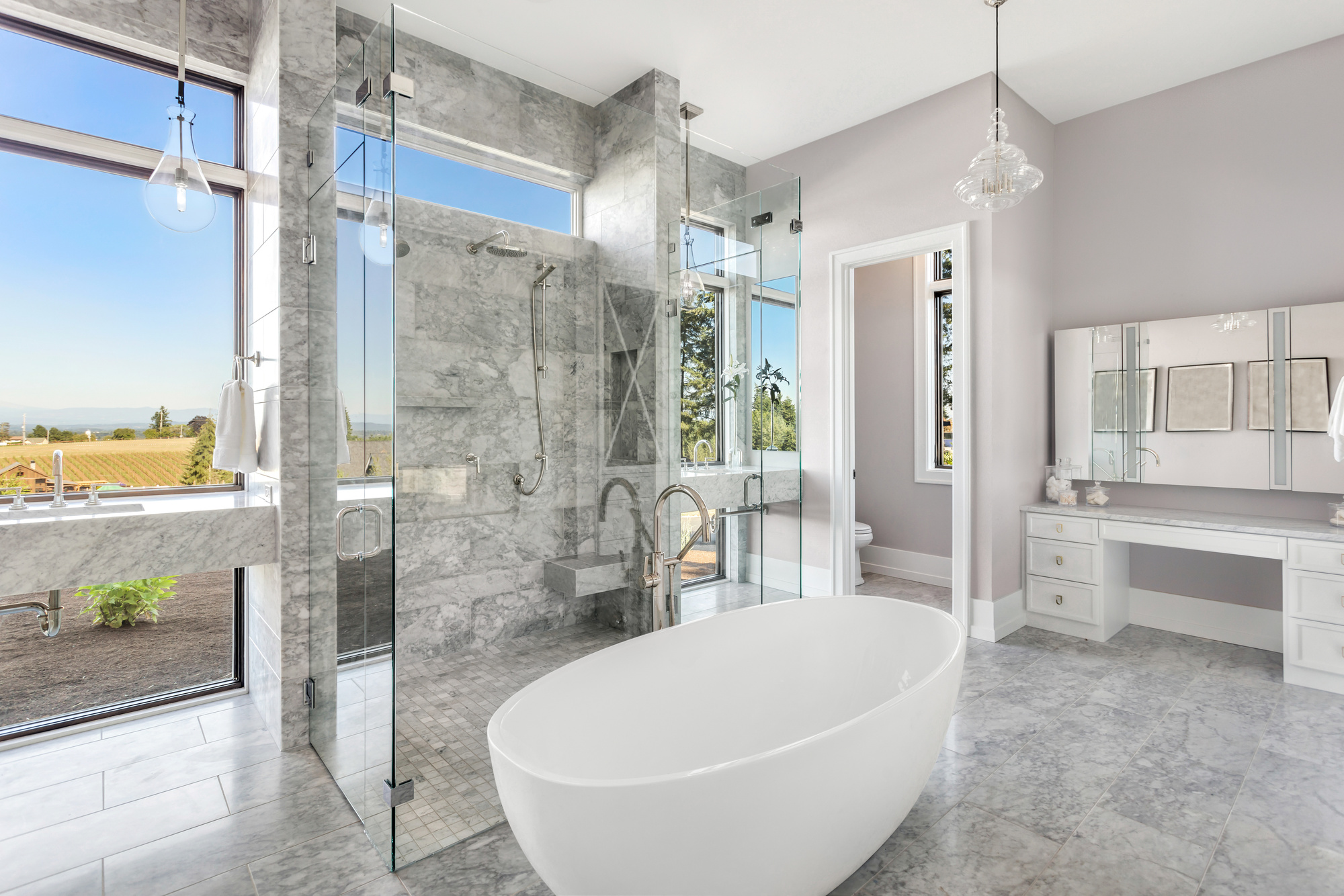 modern master bathroom interior in new luxury home with glass shower doors, and luxurious soakingbathtub